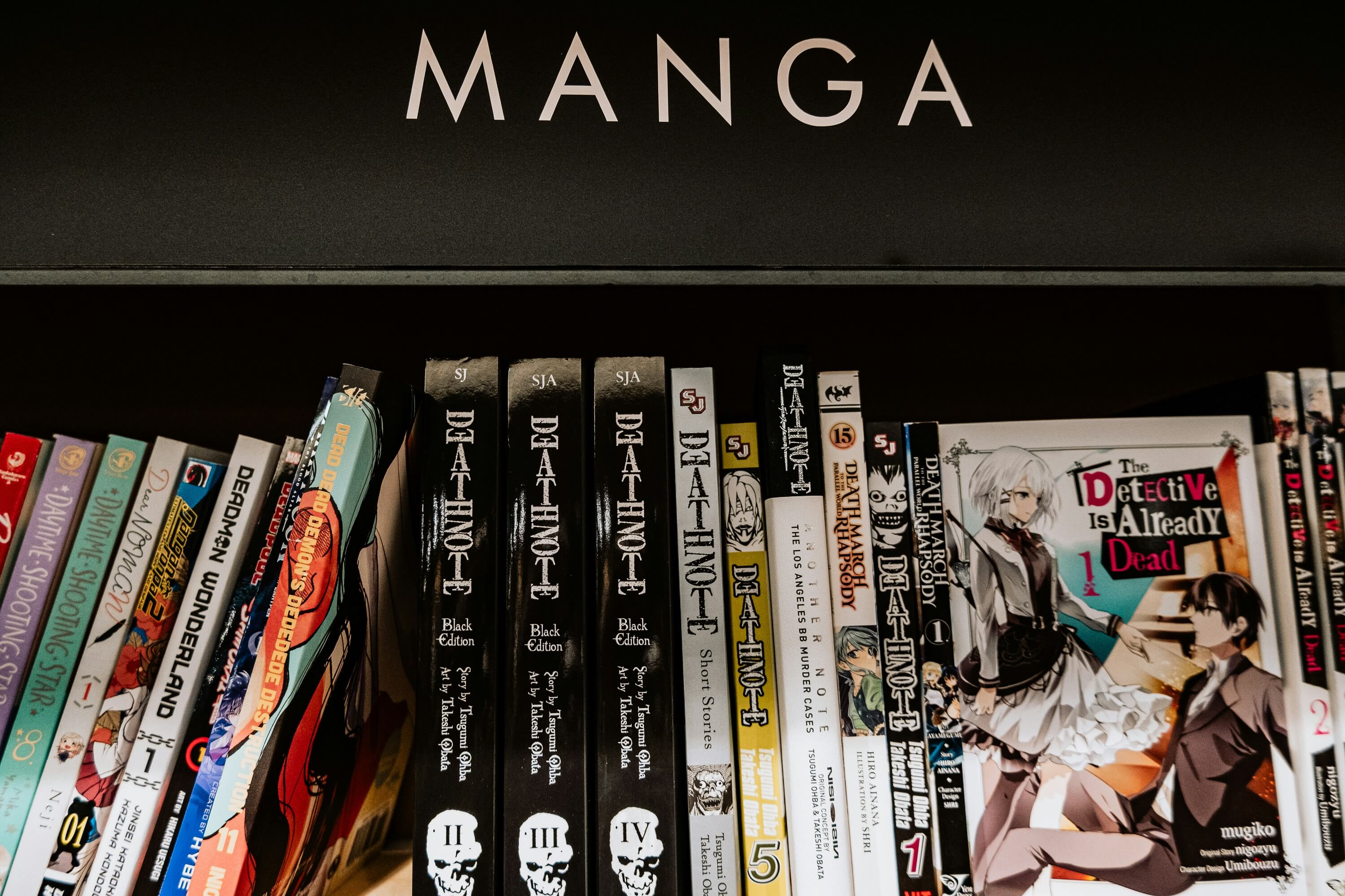 Bookshelf of Japanese manga volumes including Death Note